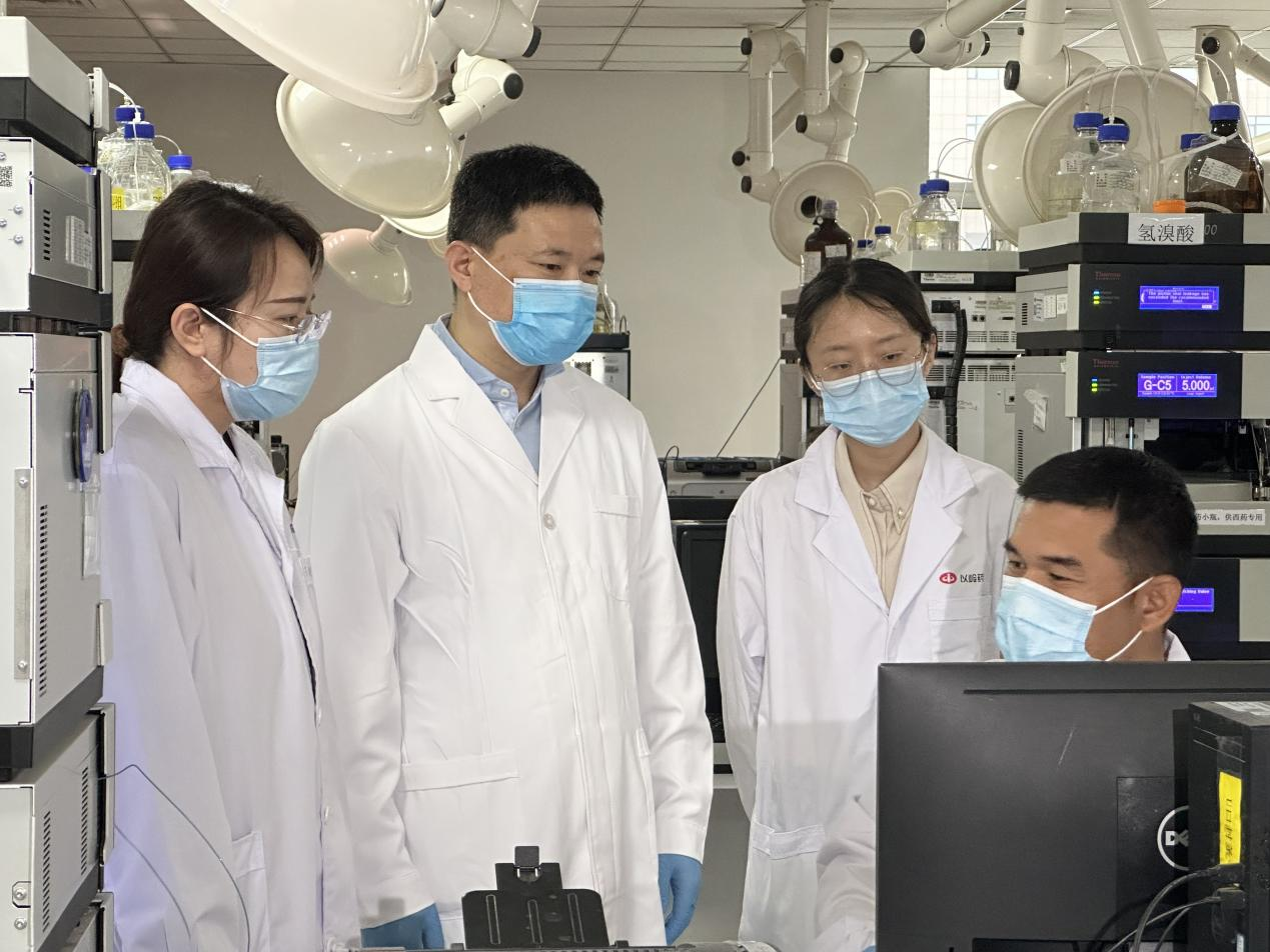 賈振華（左二）與科研人員在討論業(yè)務(wù)。 孫陽陽攝